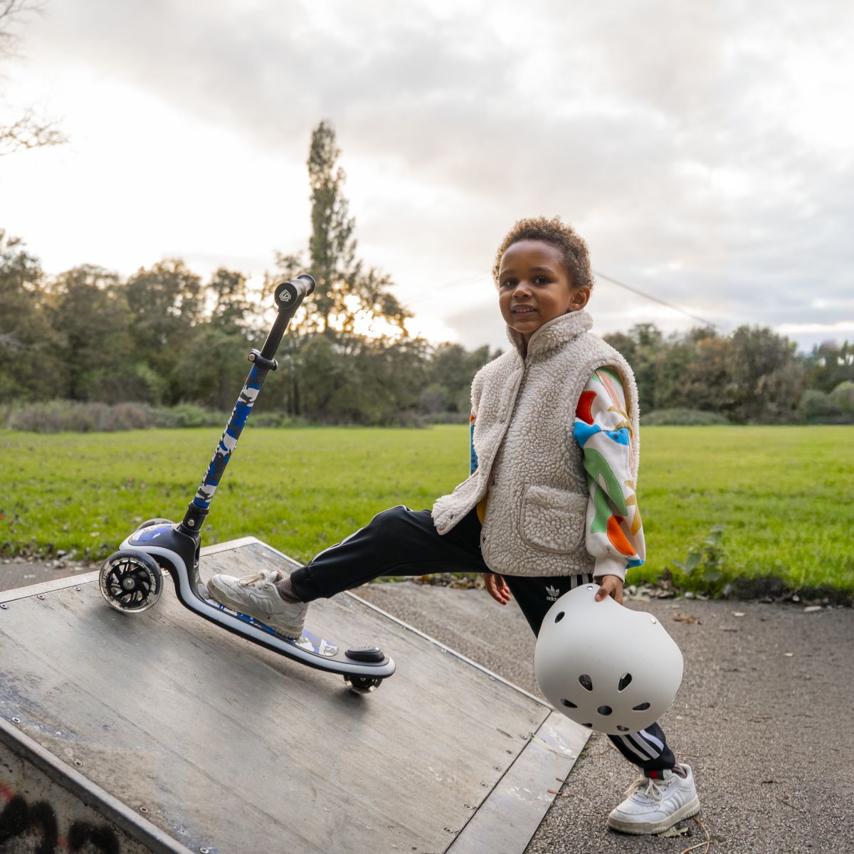 Child standing with a LIFERYDER HALO 3 wheel scooter at a skate park