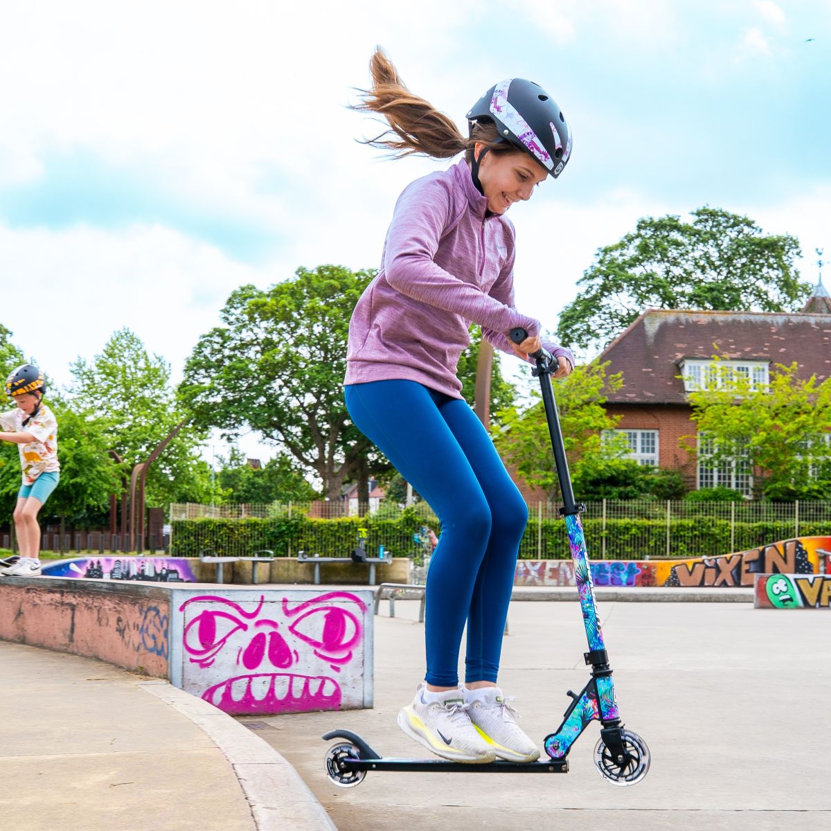 Child riding a LIFERYDER QUEST 2 wheel scooter at a skate park