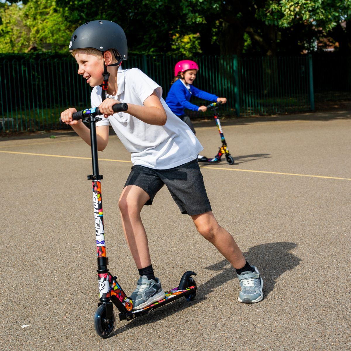 Children riding LIFERYDER QUEST 2 wheel scooters on a playground path
