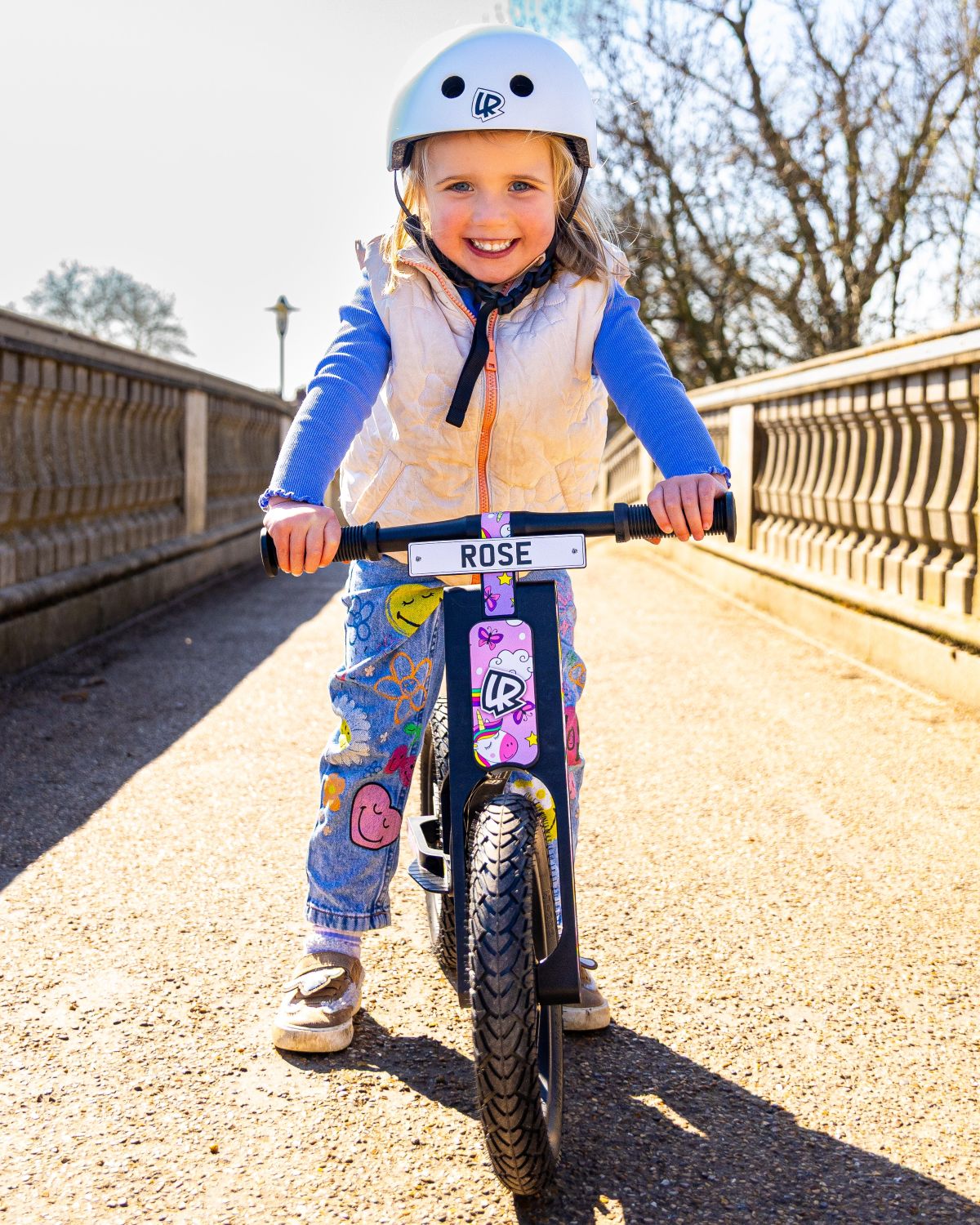Child riding a LIFERYDER VOGUE balance bike on a bridge