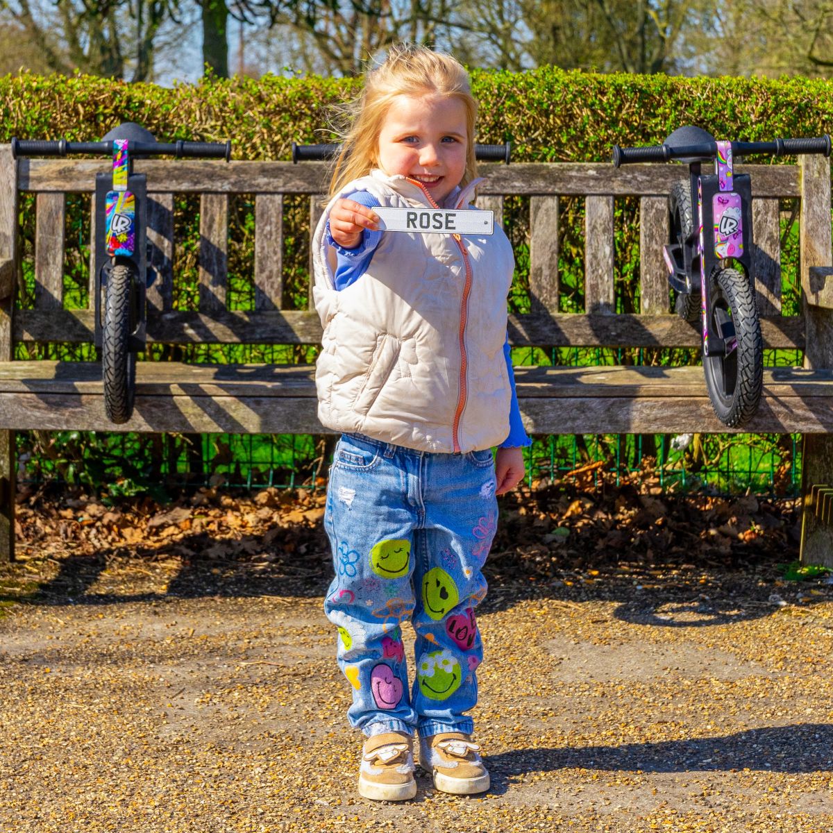 Child holding a personalised Rose mini reg plate for a LIFERYDER VOGUE balance bike
