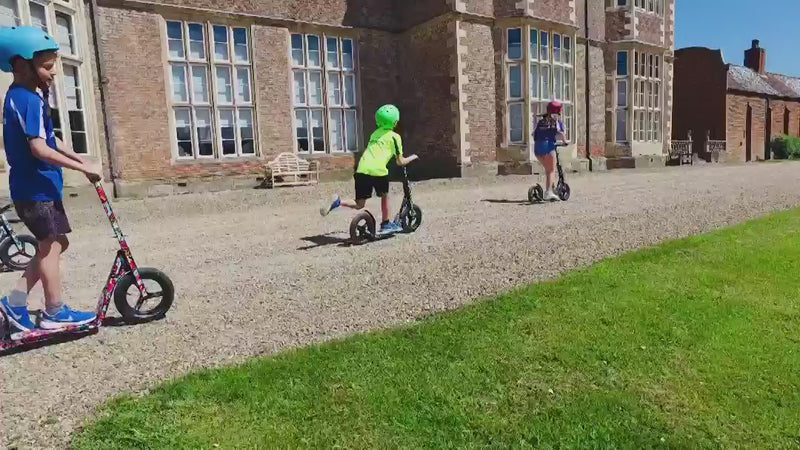 Children racing on LIFERYDER INFINITY big wheel scooters outdoors